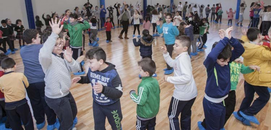 La música y el baile sustituyen a las goteras y charcos en el pabellón del colegio de Rubiáns