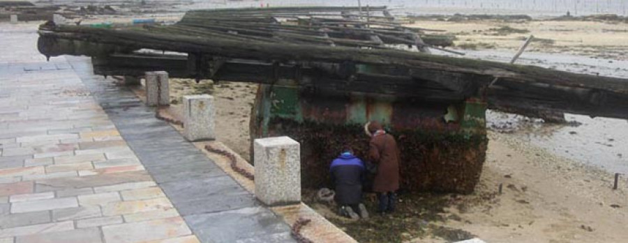 Una batea a la deriva encalla en Carril  y destroza parte del paseo marítimo