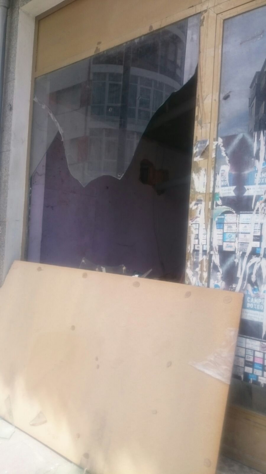 Las fuertes rachas de viento rompen la cristalera de un escaparate de un bajo comercial en desuso en Ribeira