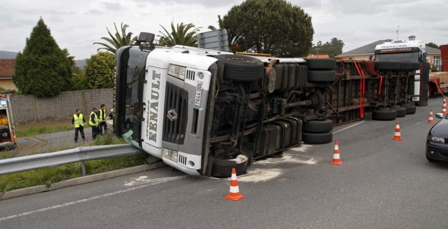 Un tráiler vuelca en la rotonda de la Vía Rápida y vierte en el arcén toda su carga de tableros