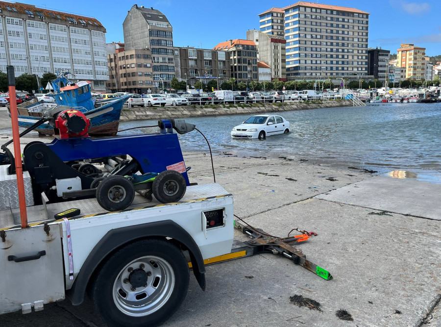 La grúa municipal de Ribeira retira un nuevo coche de la rampa del puerto que fue alcanzado por la marea