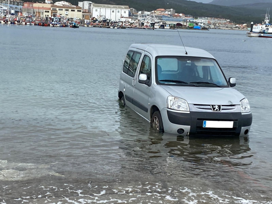 La grúa municipal retira otro vehículo atrapado por la marea en la rampa de varada de Ribeira