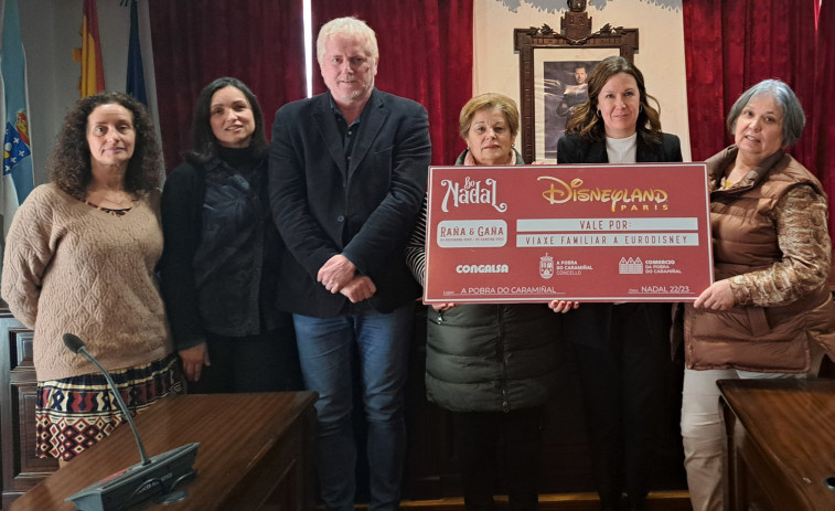 Dolores Rosende recibió el cheque regalo con el viaje familiar a Eurodisney de la campaña navideña “Raña e gaña” de A Pobra