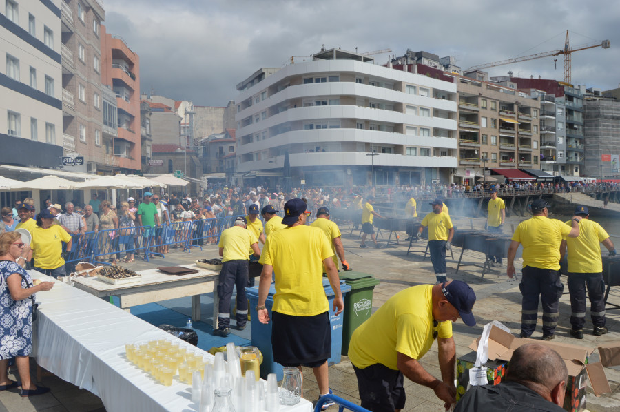 Vecinos y visitantes abarrotan la Praza dos Barcos en la tradicional sardiñada por el Día del Turista