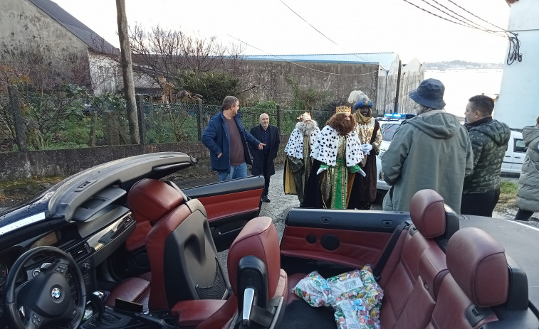 Melchor, Gaspar y Baltasar ya recorren las parroquias rurales de A Pobra en coches descapotables pese a la lluvia intermitente