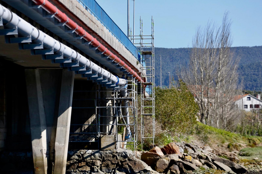 Montan los andamios para iniciar la reparación de la tubería de agua bajo el puente de Castrelo