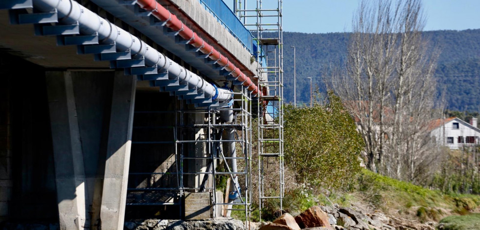 Montan los andamios para iniciar la reparación de la tubería de agua bajo el puente de Castrelo