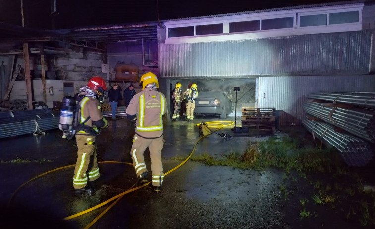 Declarado un incendio en un coche dentro de una antigua nave industrial en Meis