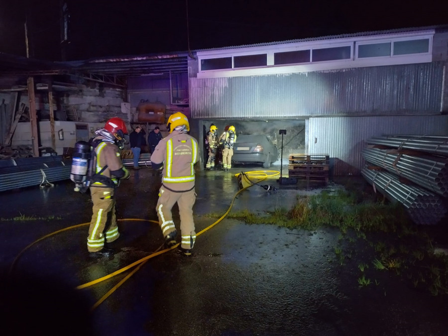 Declarado un incendio en un coche dentro de una antigua nave industrial en Meis