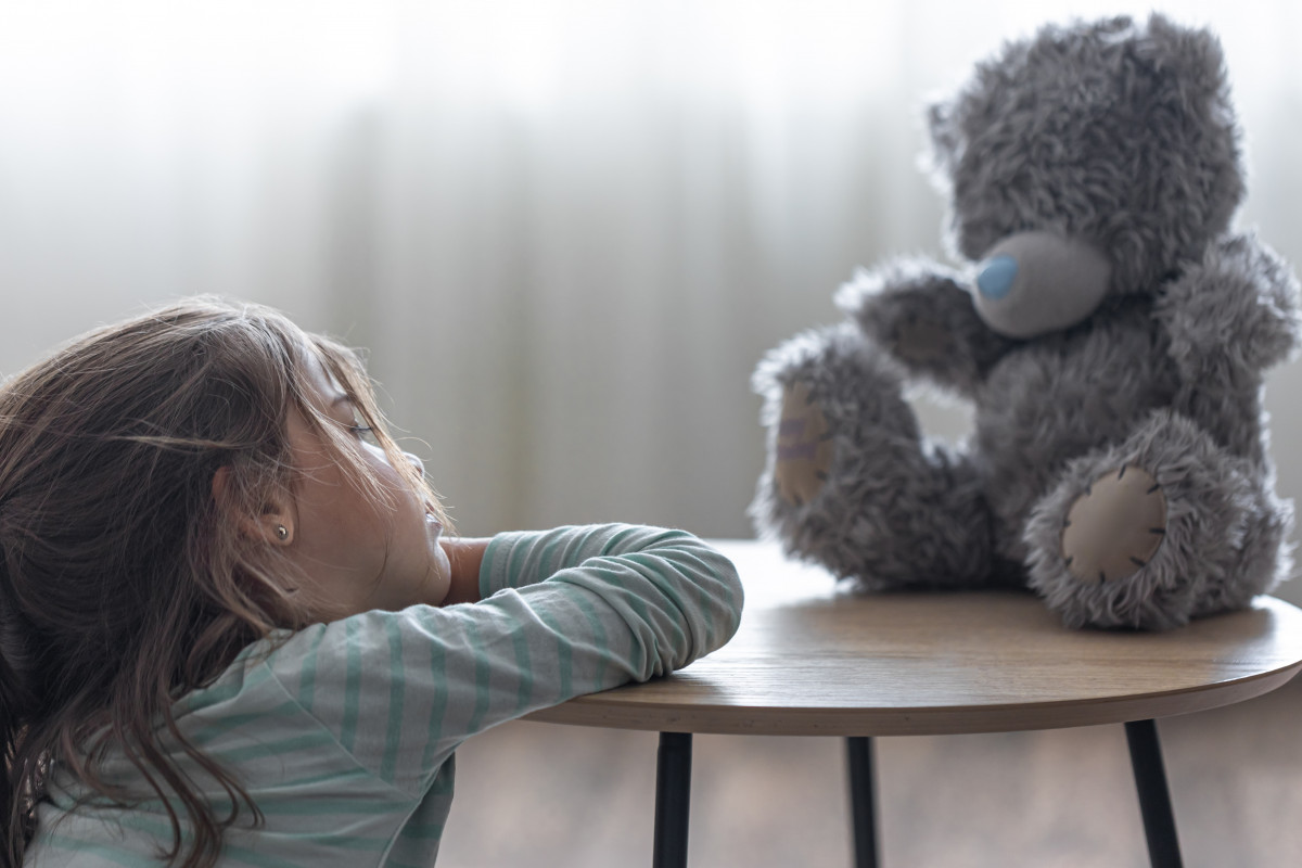 Nina mira su osito de peluche un nino con un juguete favorito en un espacio de copia de fondo borroso