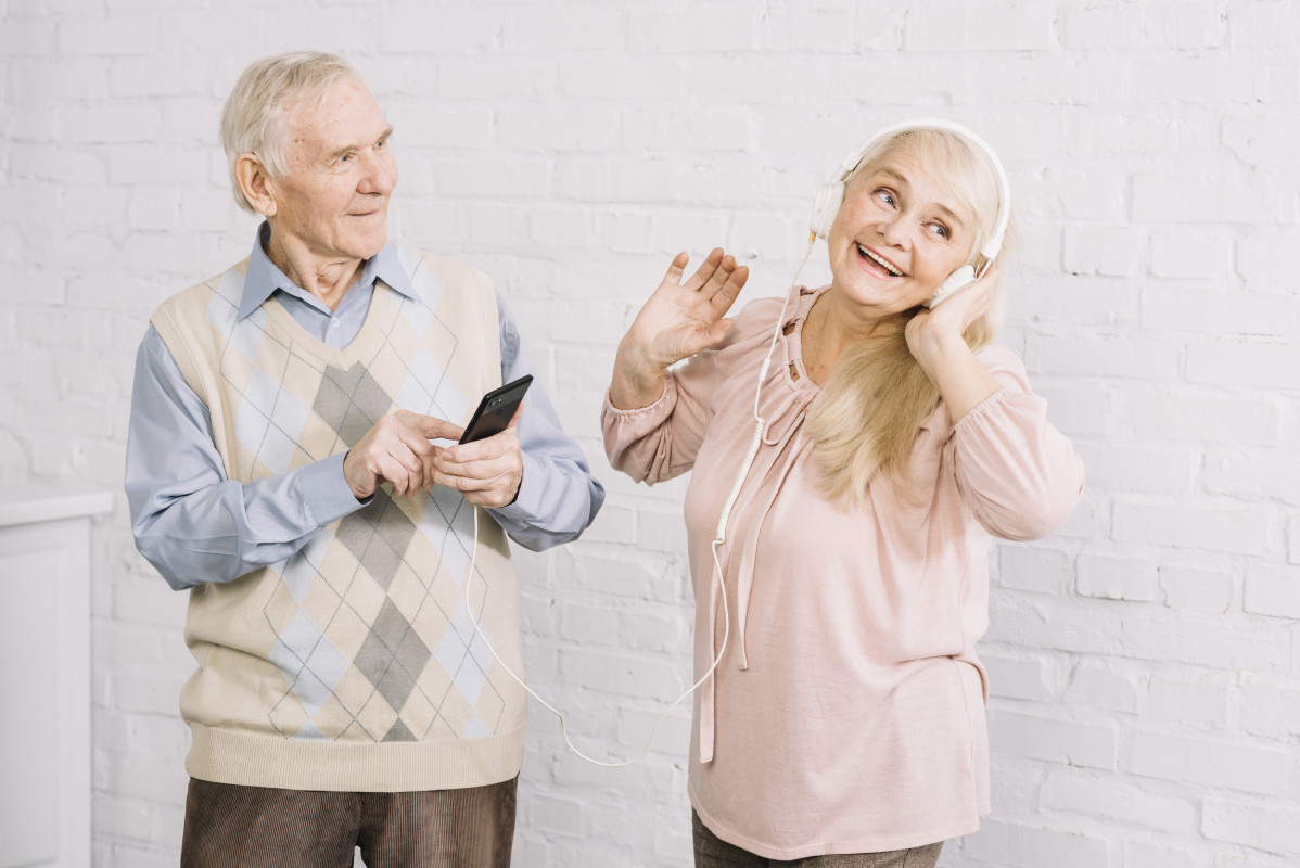 Pareja mayor escuchando musica en smartphone