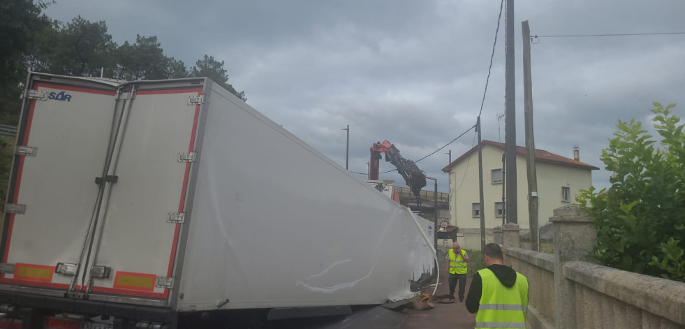 Un camión de reparto queda atrapado bajo el puente de Catoira y choca contra un muro y un portal al dar marcha atrás
