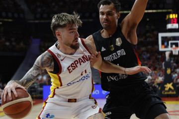 El ala pívot de la selección española de baloncesto Juancho Hernangómez (i) juega un balón ante un jugador alemán, durante el pa